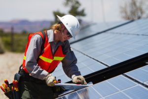 Crédito para programa de eficiência energética em Curitiba: homem instalando painel solar