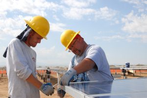 Instalação de usina fotovoltaica: operários instalando módulo fotovoltaico