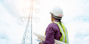 Projeto elétrico: imagem de projetista segurando projeto elétrico